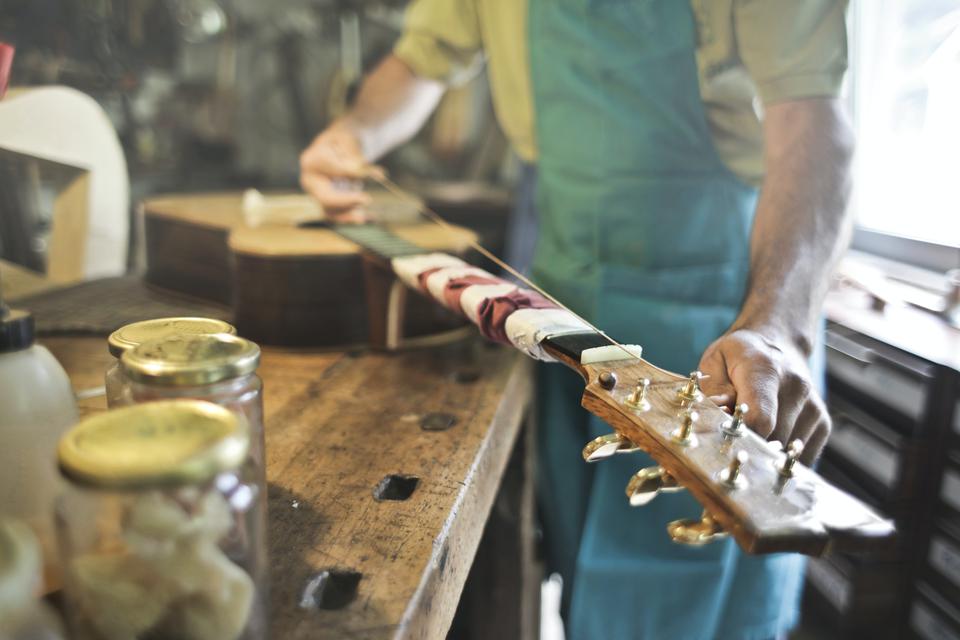 Un luthier en train de régler une guitare